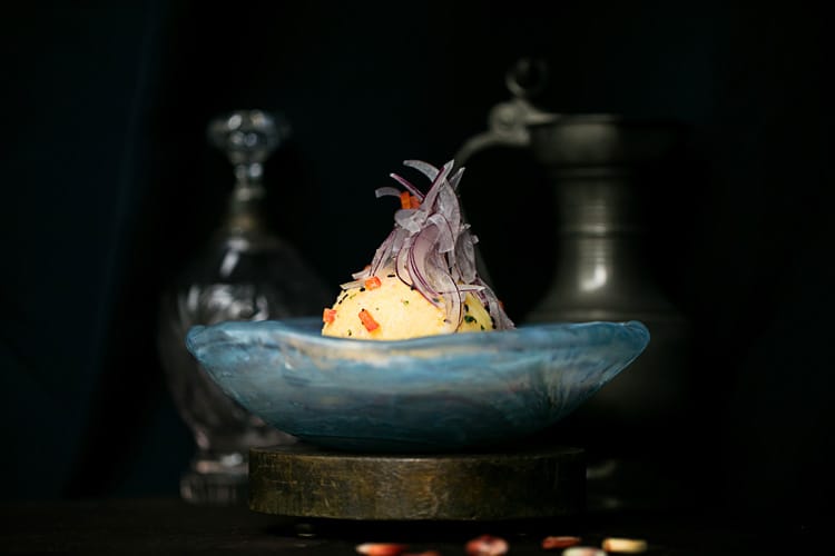 Plato con causa peruana de pulpo al Olivo con papa amarilla y cebolla morada.