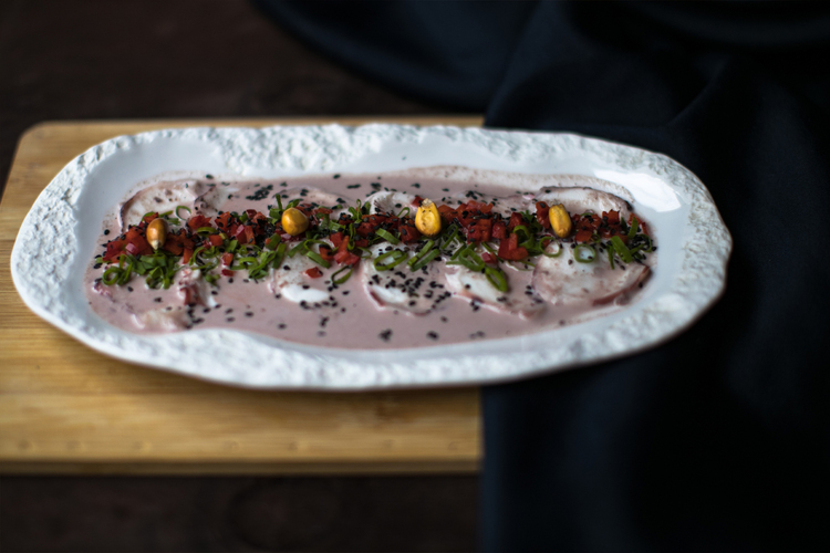 Tiradito peruano de salmón con salsa de ají, maíz tostado y semillas de sésamo.