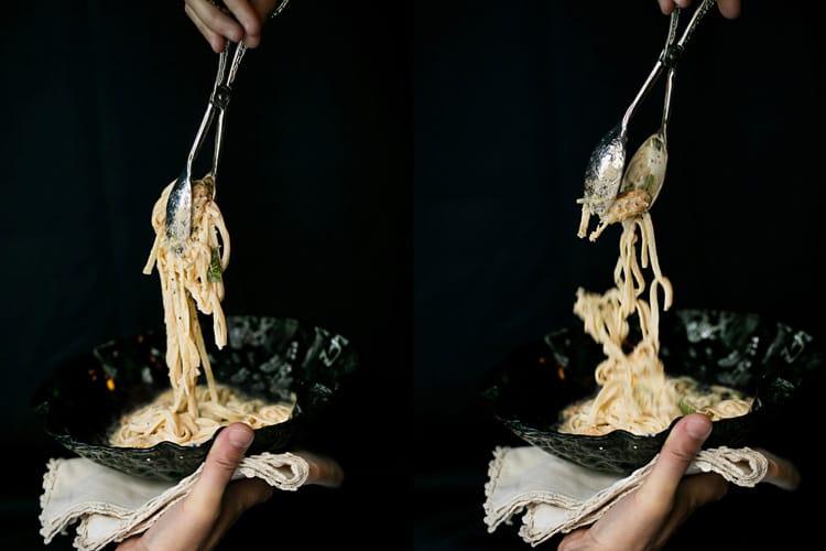 Sirviendo platos de tallarines con langostino, coco y curry sobre plato de cristal.