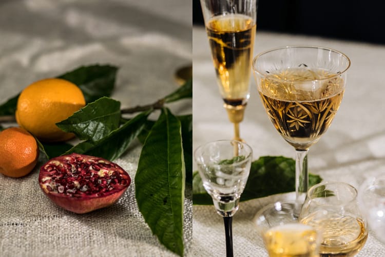 Naranja, mandarina, pomelo y copas de champagne sobre mantel de tela.