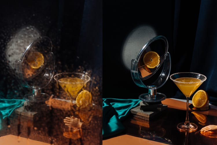 Set fotográfico con espejo de pie enfocado a copa de cóctel de naranja.
