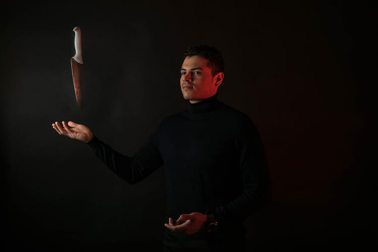 Chef hombre levitando un cuchillo de cocina sobre la mano.